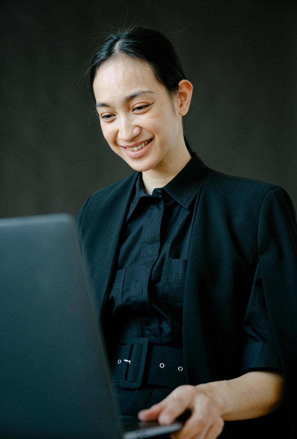 A freelancer smiling while working on a laptop