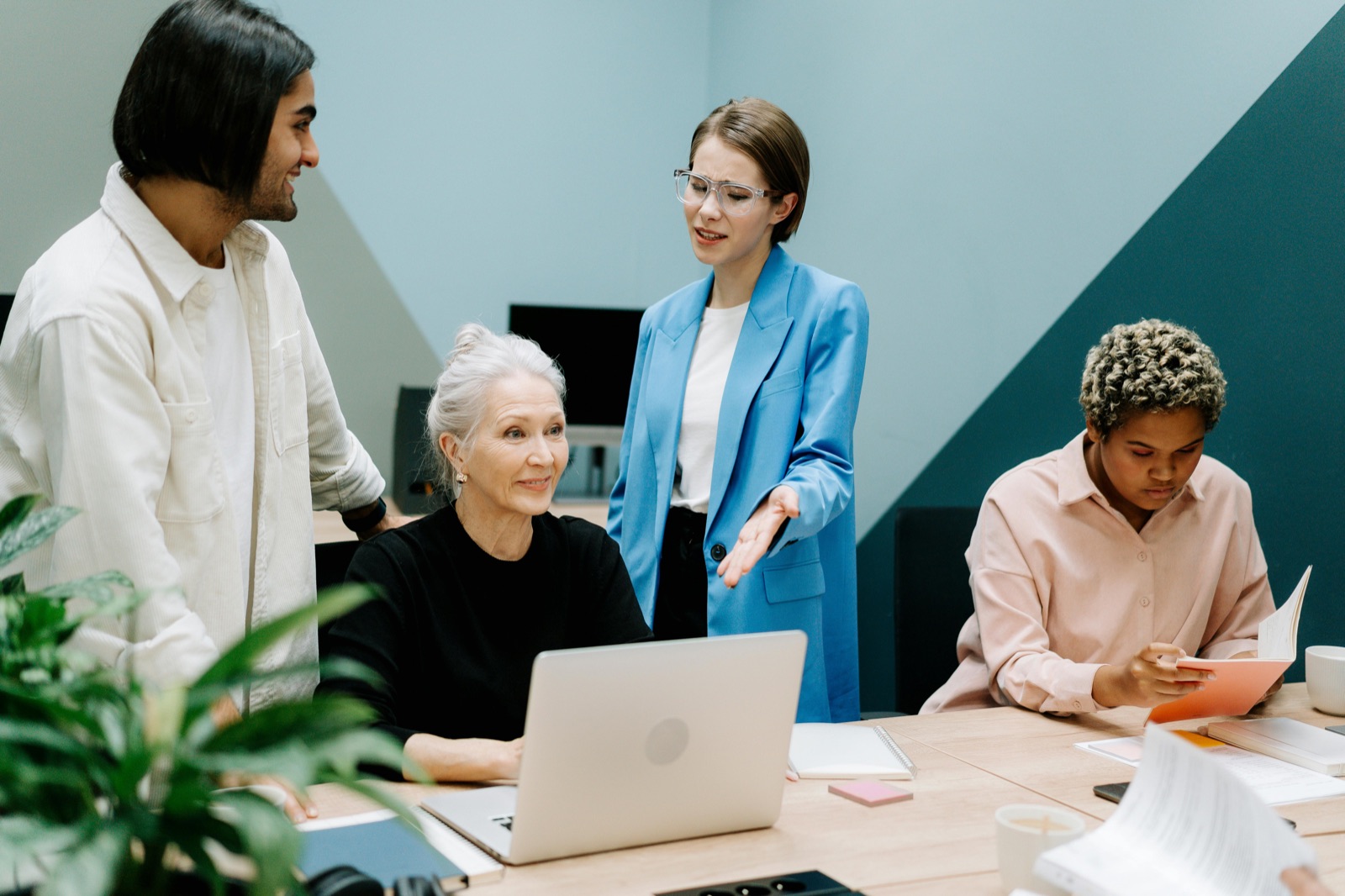 A team reviewing project proposals together at a laptop